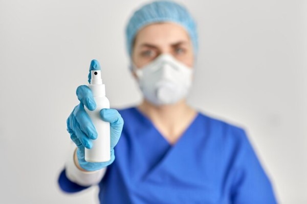 enfermera mostrando un spray de preanestesia para una cirugía de implante capilar