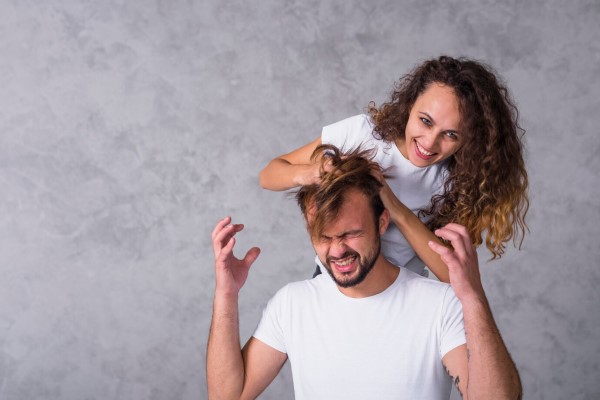 pelo de los hombres - mujer sonriente revolviendo el cabello de un hombre