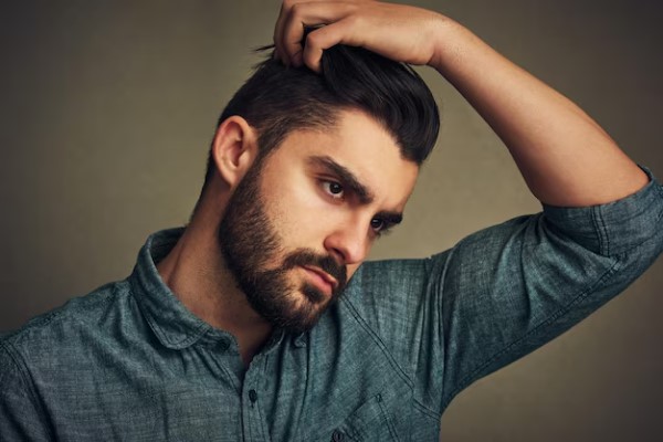 pelo de los hombres - hombre pasándose la mano por su melena con un cabello espectacular