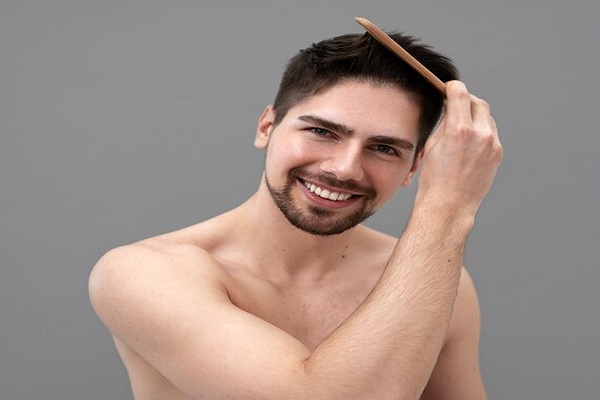 pelo de los hombres - hombre sonriente peinando su cabello