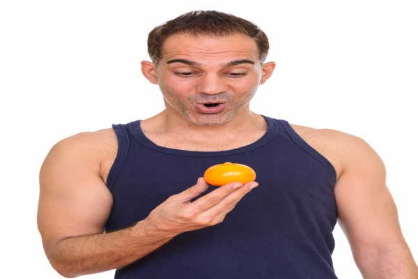 teñirse el pelo 2 - hombre a en la ultima parte del injerto capilar con una naranja en la mano