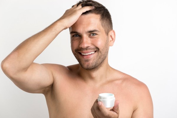 hombre aplicando una mascarilla capilar a su cabello a los meses de realizarse un injerto capilar