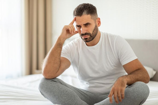 Hombre con dolor de cabeza tras injerto de cabello espera que los analgésicos hagan efecto