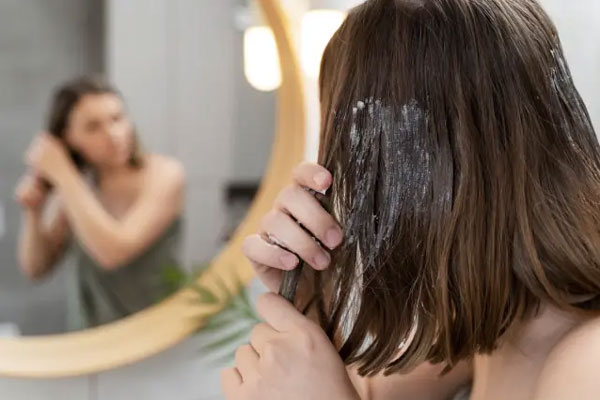 Mujer aplica una mascarilla capilar casera para hidratar y revitalizar el cabello de manera profunda
