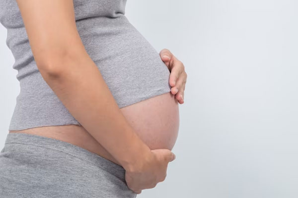Vista lateral de la barriga de una mujer embarazada