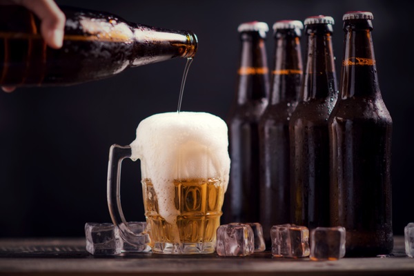 Cerveza para el cabello - Persona sirviendo una cerveza sin alcohol en un vaso de vidrio