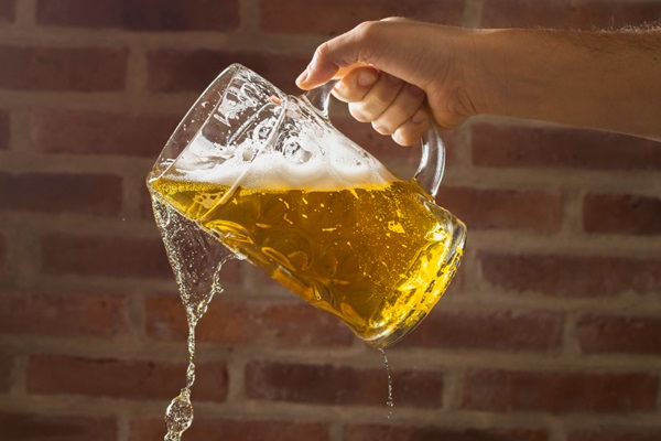 Cerveza para el cabello - Persona derramando un vaso de cerveza ligera que aporta nutrientes gracias a la levadura de la cebada