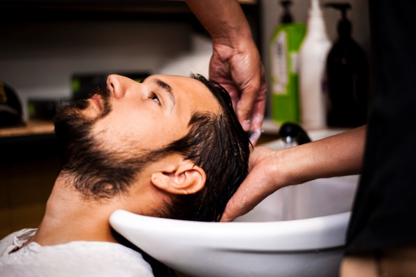 Masajes capilares - Hombre joven recibiendo un masaje capilar para estimular el crecimiento del cabello
