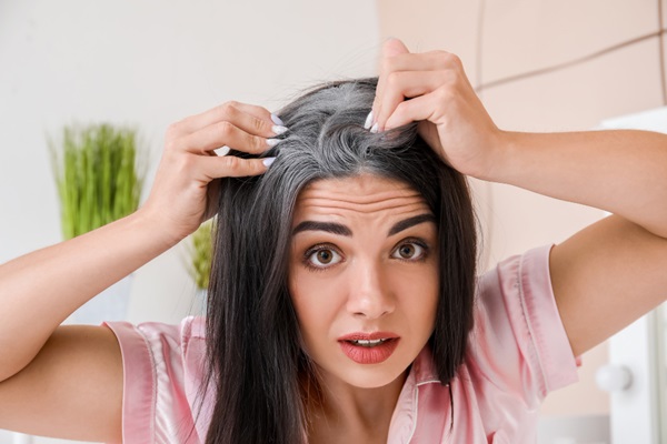 Síndrome de Waardenburg - Mujer con cara de asombro sujetando con las manos los mechones de cabello blanco debido a las canas