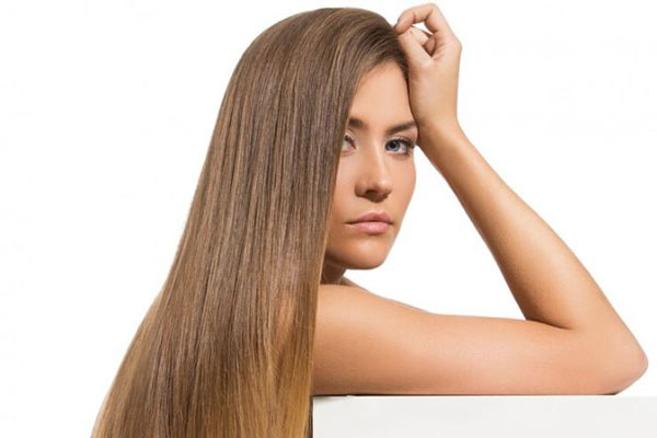 Peinar cada tipo de pelo - Mujer de cabello liso y largo usa productos capilares especiales para estimular el crecimiento del cabello