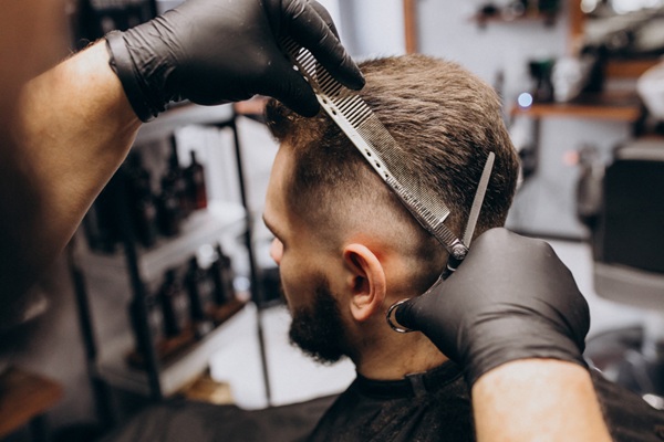 Trucos de cabello - Estilista cortando el cabello de un hombre para crear un estilo moderno y juvenil