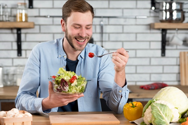 Cuidados para embellecer el cabello - Hombre sosteniendo un recipiente con frutas y hortalizas para comer saludable y fortalecer el pelo
