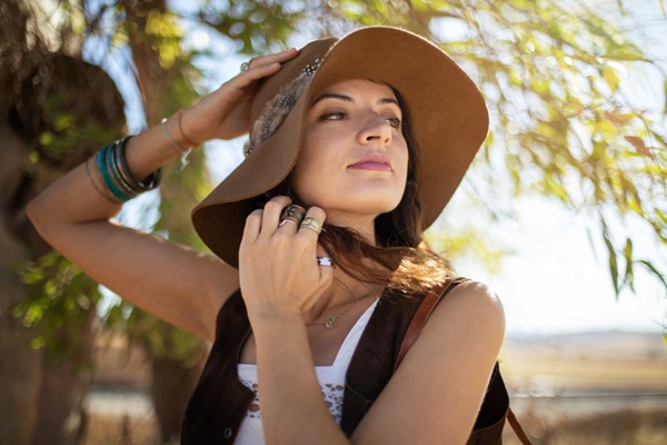 Mujer usando un sombrero para proteger el pelo del sol y evitar la deshidratación de la hebra capilar