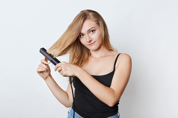 Formaldehído - Mujer joven usando una plancha para alisar el cabello sin usar tratamientos químicos