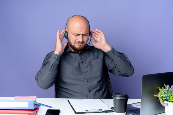 Consecuencias de la alopecia - hombre con problemas graves de alopecia en el trabajo con depresión