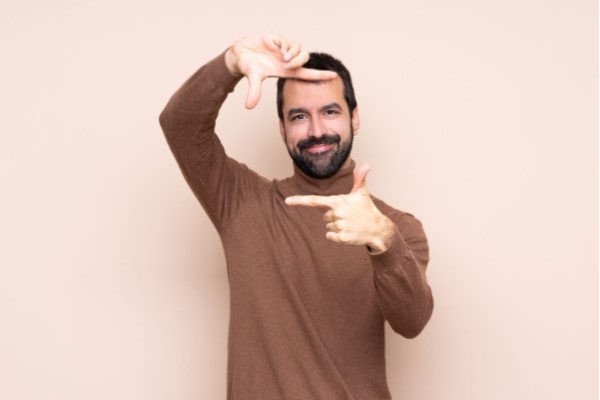 trasplante de pelo - hombre blanco encuadrando su cara con los dedos feliz con su imagen personal