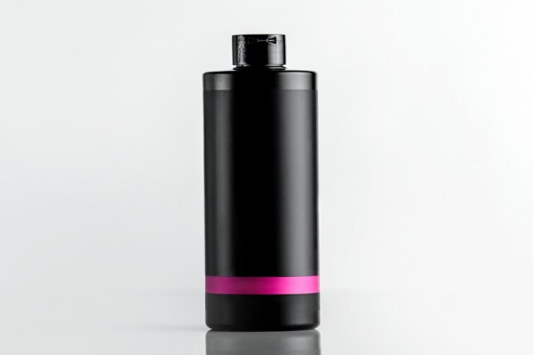 Champú para la caída del cabello - Vista frontal botella de plástico negro debajo del champú con una franja rosa