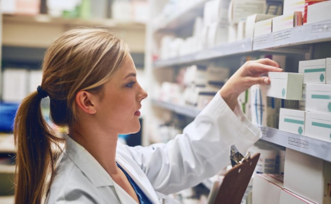Captura de un farmacéutico mirando un medicamento en un estante
