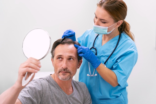 Injerto de cabello costo - Médico especialista evaluando el cuero cabelludo de un hombre con alopecia para determinar el injerto capilar precio