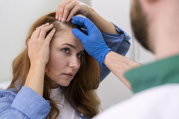 injerto de cabello en Colombia - mujer en la consulta del especialista revisando la densidad de su cabello en la zona de las entradas