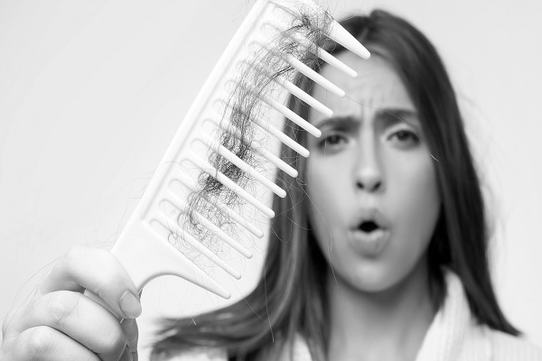 Falacrofobia, mujer con una visible perdida de cabello en su peine de cerdas separadas