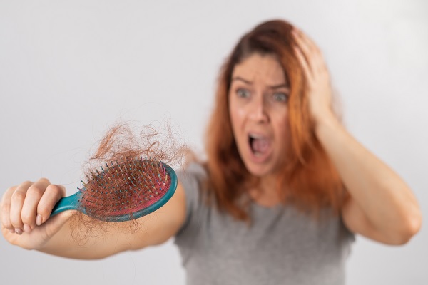 Falacrofobia - mujer visiblemente alterada por la perdida del cabello en su cepillo