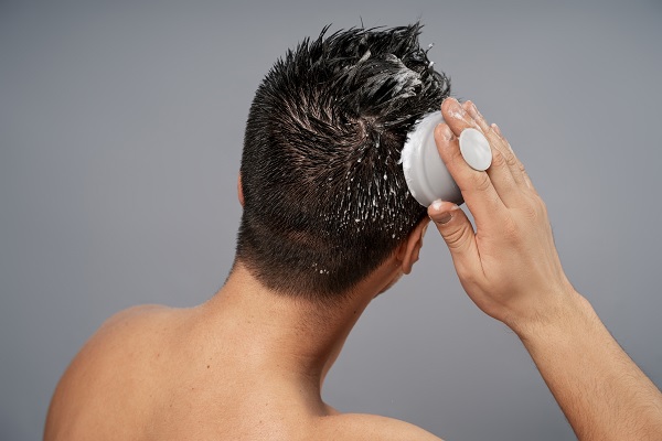 hombre lavando su cabello, como cuidado posterior del injerto de cabello