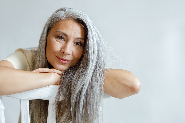 canas prematuras, mujer de mediana edad con el cabello largo y canoso