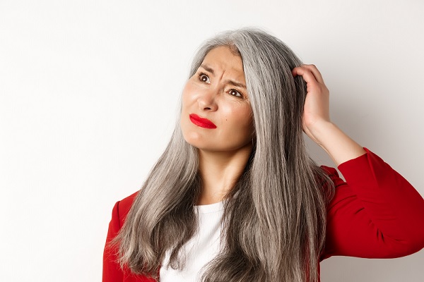 canas prematuras, mujer con cabello gris luciendo un poco confundida