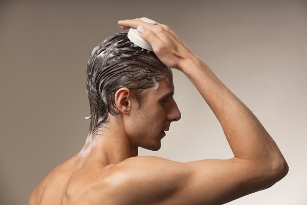 trasplante cabello, un hombre se lava el cabello usando un masajeador, esto es beneficioso para mantener la salud del cabello y también es beneficioso para el injerto de cabello