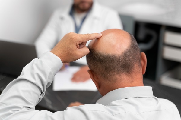 trasplante capilar Colombia - un hombre calvo en cita con un especialista en trasplante de cabello, discutiendo el precio del procedimiento
